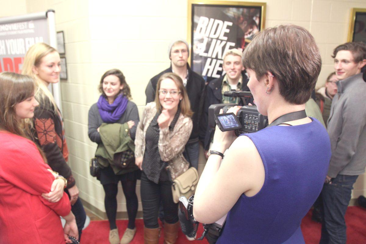 The first students in line on the red carpet are interviewed by CMF while waiting for the Saturday night premiere.