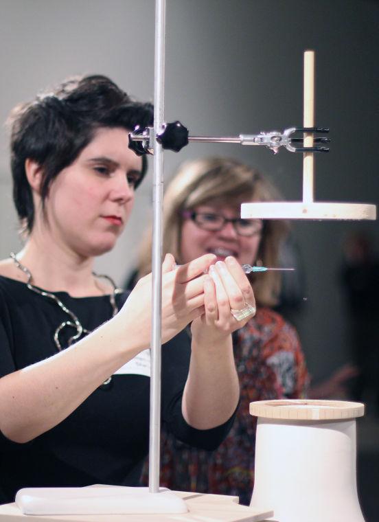 Kate Shafer, the gallery and exhibitions manager for the Contemporary Art Museum, demonstrates Alistair McClymont&#8217;s &#8220;Raindrop&#8221;, which features a single drop of water suspended in mid-air. According to the CAM website, Raindrop is based on a machine made by the University of Manchester in the early 1970s to study rain.&#160;