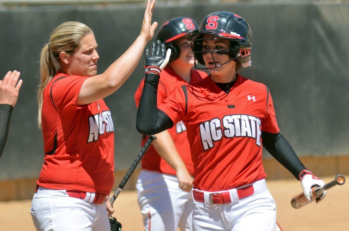 Sophomore third baseman Scout Albertson high fives her teammates after scoring a run against Boston College Saturday, April 7, 2012. Albertson went 1 for 3 with 1 walk and 1 run in the 7-1 Wolfpack win.