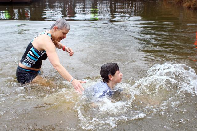 Brooks Downs helps Billy Fuller out of Lake Raleigh for the eigth annual N.C. State Polar Plunge February 23. At twelve years of age, Fuller was the second youngest participant of the plunge. Photo by Katherine Hoke