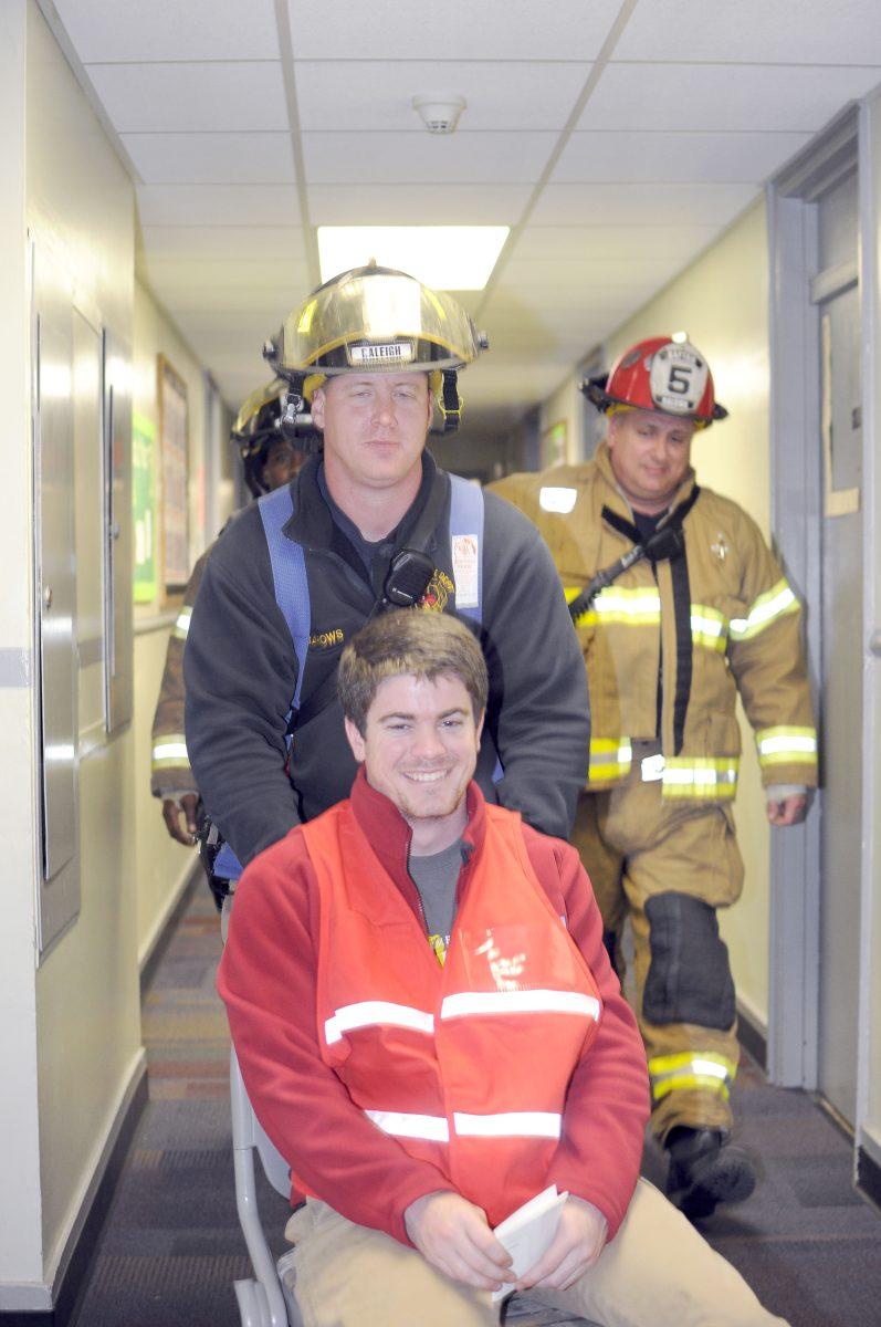 Sam Hipps, a senior in history is wheeled out of Owen Residence Hall as a part of Operation Wolfpack Shelter Wednesday, March 13. The operation, which simulated a tornado hitting Central Campus, involved the Tri-Towers, Tucker and Owen Halls.