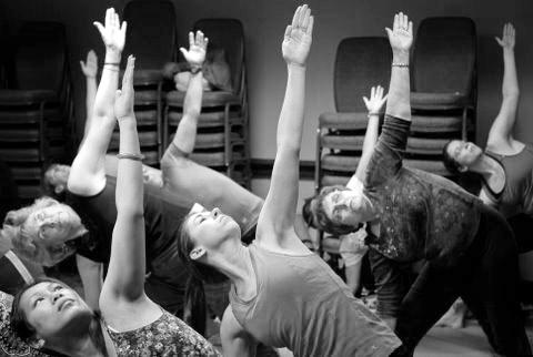 Participants attempt to master the extended triangle pose, or utthita trikonasana, during one of the yoga classes conducted by the staff at YogaFest NC 2012.