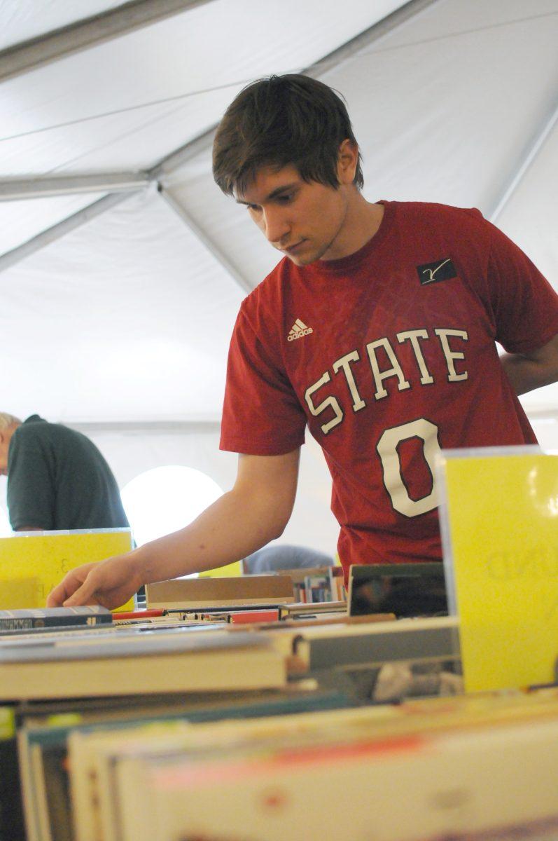 Dragan Lipovac, senior in economics, looks through books at the annual Memorial Booksale in the Brickyard on Monday, April 22, 2013. "I came here last year on the last day, but I tried to come early this year," Lipovac said. "I got about 10 books last year, so I hope to find more this time around." Photo by: Sam O'Brien