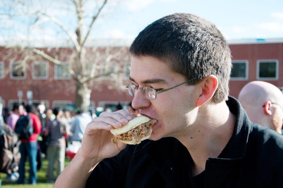 Josh Warden, a sophomore in animal science enjoys some barbecue at Taste of N.C. State, which showcased foods from around the world. "It gives everybody an idea of what foods they can get locally while still giving them a variety, plus the food's good and it's free." Photo by Chris Rupert