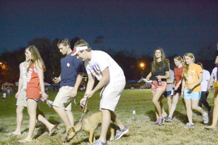Michael Brooks, a sophomore in mechanical engineering, walks his dog during the Relay for Life on March 13. Hundreds of students went to the Greek Village field to support research in cancer. Many fraternities and other student organizations set up booths to raise money for the cause.
