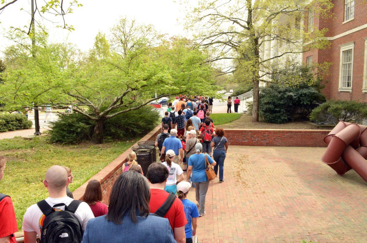 NC State students follow Program Coordinator of the African American Cultural Office, Toni Thorpe and Associate History Professor, Walter Jackson on the Red, White, and Black March. A tour that features historial sites that contribute to the de-segregation of NC State. Photo by Merari Valencia