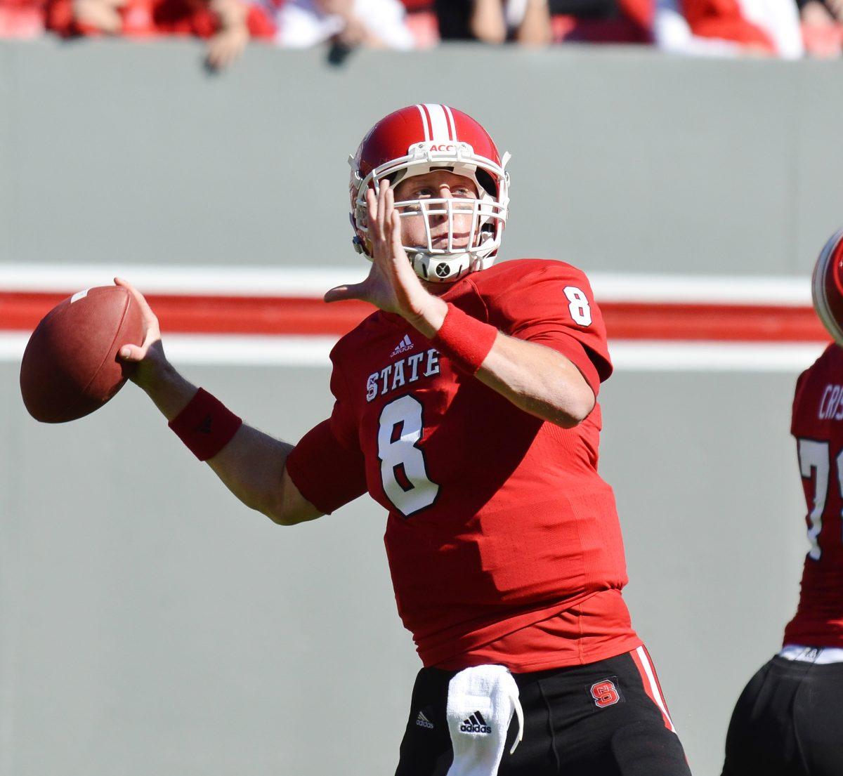 Graduate student quarterback Mike Glennon goes to pass the ball as junior offensive tackle holds back a defender during the homecoming football game in Carter-Finley Stadium Saturday, Nov. 3, 2012. The Cavaliers routed the Wolfpack 33-6. Photo by John Joyner.