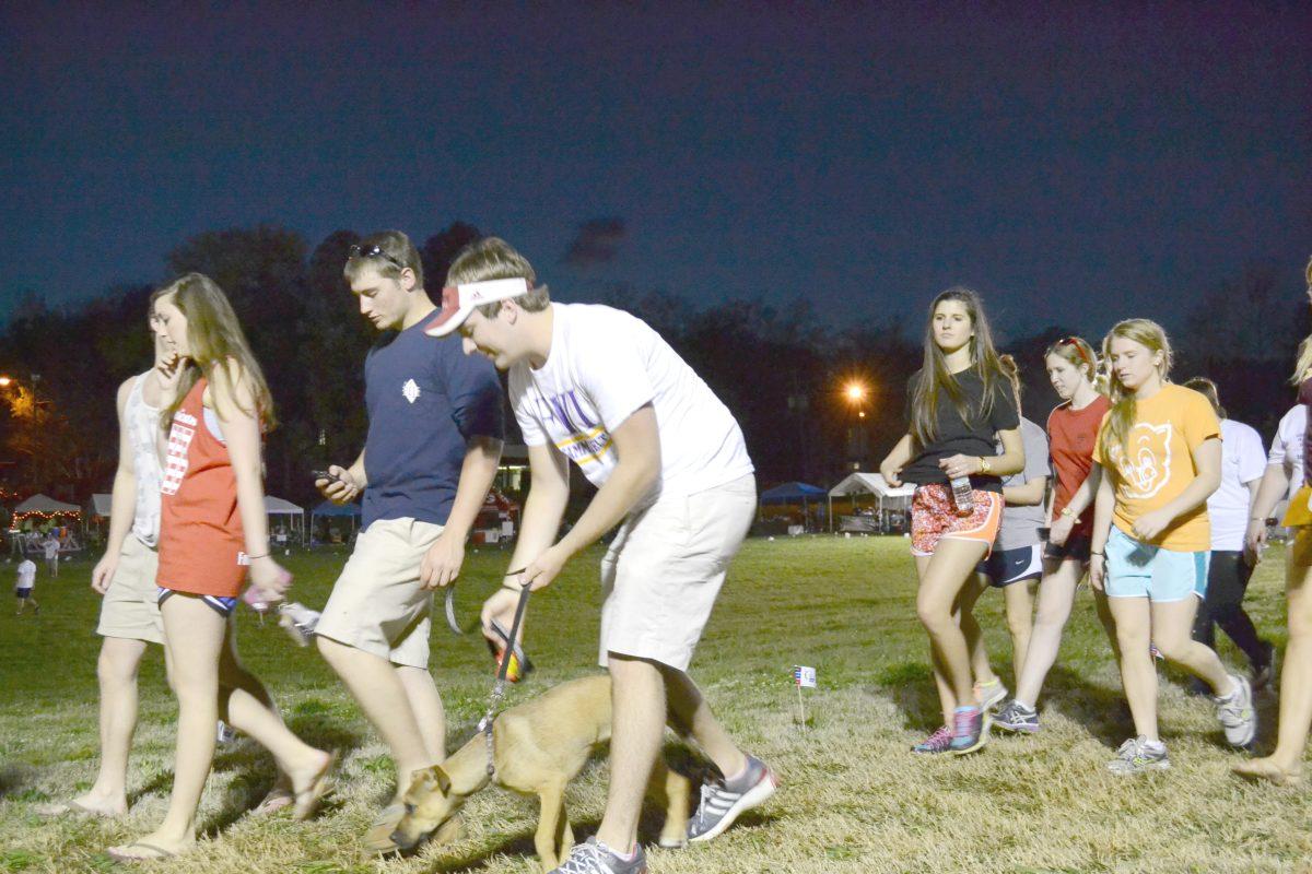 Michael Brooks, a sophomore in mechanical engineering, walks his dog during the Relay for Life on March 13. Hundreds of students went to the Greek Village field to support research in cancer. Many fraternities and other student organizations set up booths to raise money for the cause.