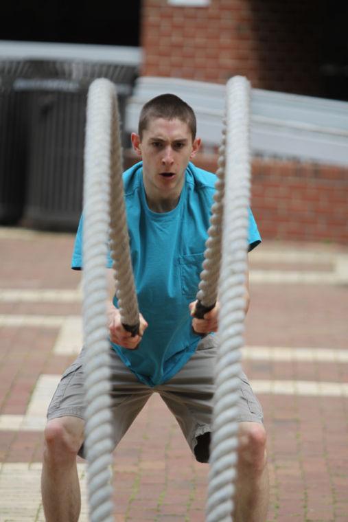 Photo by Joannah Irvin. Joseph D'Alessandro, a junior in biological sciences, whips ropes during the Grow in Your Wellness in the Brickyard on Tuesday, April 16. The ropes were a part of the obstacle course set up by the University Recreation to promote different ways of staying fit. "I am very interested in cross-ft," D'Alessandro said, "It is much better than regular weight training or running on the treadmill".