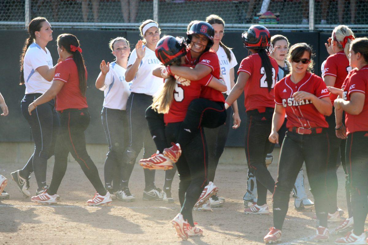 Senior center fielder Caitlin Dent embraces shortstop Renada Davis after hitting a game-winning walf-off homerun during the second game of the three-game series against UNC April 13, 2013 at the Curtis &amp; Jacqueline Dail Softball Stadium. The Wolfpack took the series 2-1, taking them to 7-7 in the ACC and 23-18-1 overall. Photo by Caide Wooten.