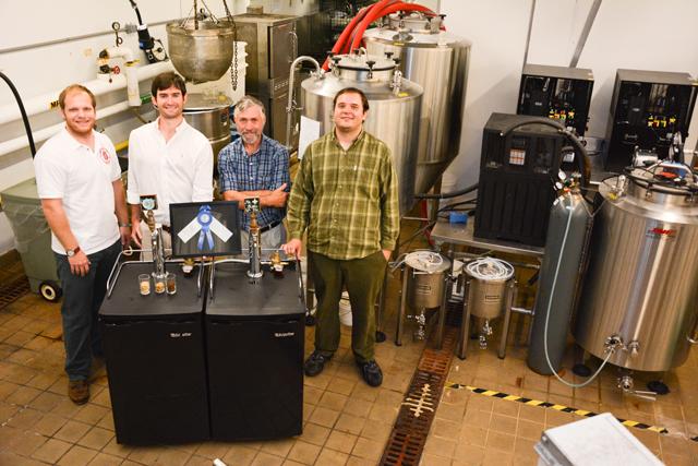 Joseph Hildebrand, Black Layfield, John Sheppard and Thomas Clawson stand in the brewery in the Pilot Plant of the Schaub Food Science Building. The brewery is part of the master's program offered by the Food Science Department. Photo by Chris Rupert.