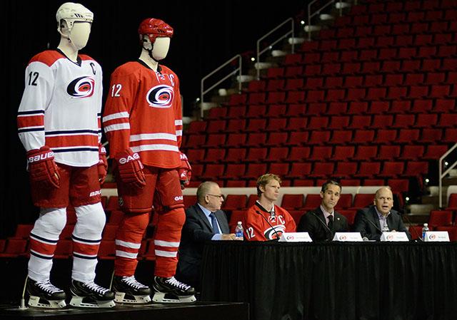 The new Carolina Hurricane uniforms are modeled beside President and General Manager Jim Rutherford, captian Eric Staal, Executive Director Doug Warf, and Senior Director of Marketing and Brand Development Ben Aycock at the unveiling event and press conference at the PNC Arena Tuesday, June 6, 2013. Photo by Ryan Parry.