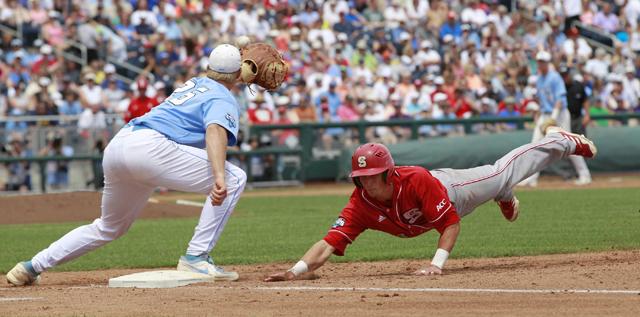 N.C. State's Jake Armstrong (23) dives back safely to first as North Carolina's Cody Stubbs (25) waits for the ball in the second inning in the College World Series, Sunday, June 16, 2013, at TD Ameritrade Park in Omaha, Nebraska. N.C. State won, 8-1. (Ethan Hyman/Raleigh News &amp; Observer/MCT)