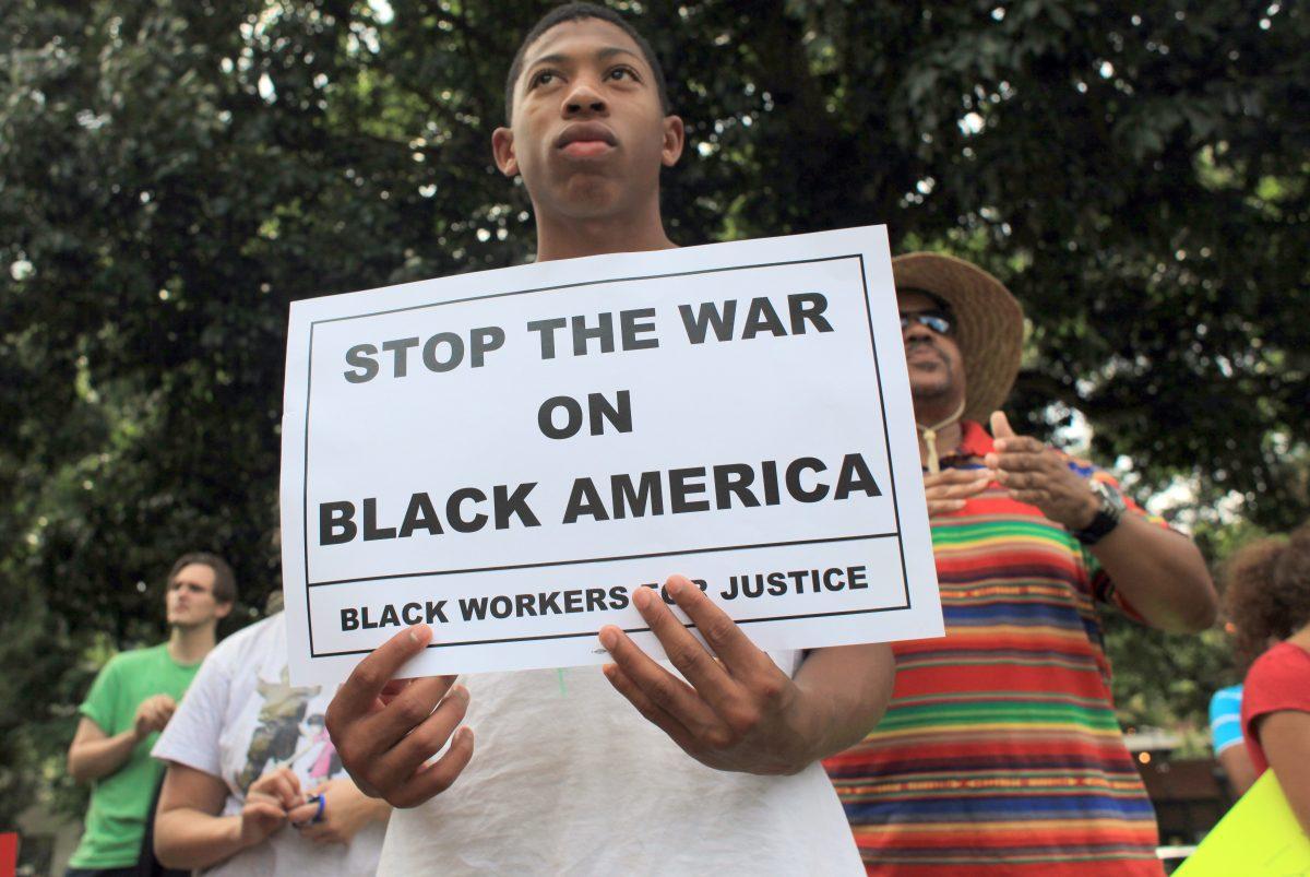 Emmanuel Thombs, 13, rallies with about 100 people to protest the not-guilty verdict in the George Zimmerman murder trial Sunday, July 14, 2013, at Moore Square in downtown Raleigh.