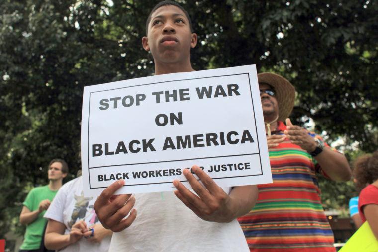 Emmanuel Thombs, 13, rallies with about 100 people to protest the not-guilty verdict in the George Zimmerman murder trial Sunday, July 14, 2013, at Moore Square in downtown Raleigh.