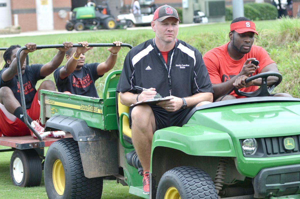 Strength and Conditioning coach Jason Veltkamp and Graduate Assistant Sterling Lucas ride in a gator pulled by players at Lift for Life July 25, 2013.