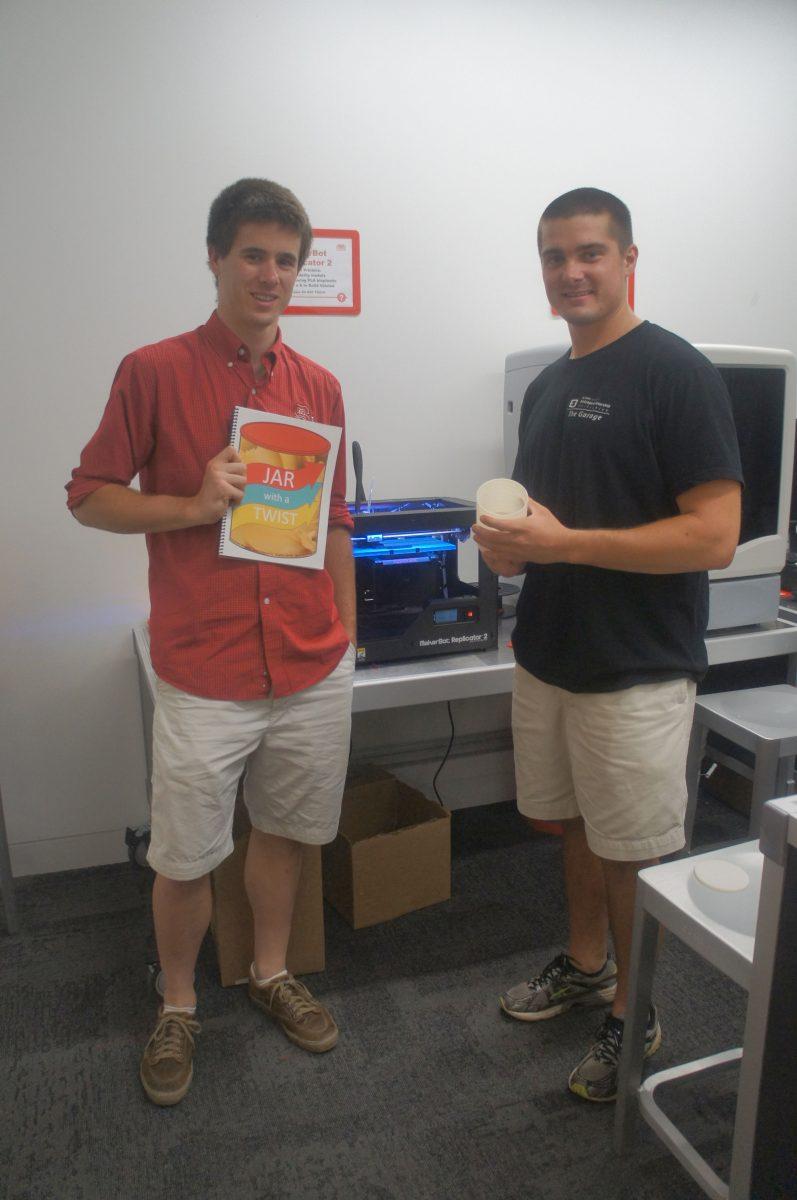 Stephen Smith, left, and Michael Bissette, right, pose with their business model, 3D printer, and model of jar with a twist.