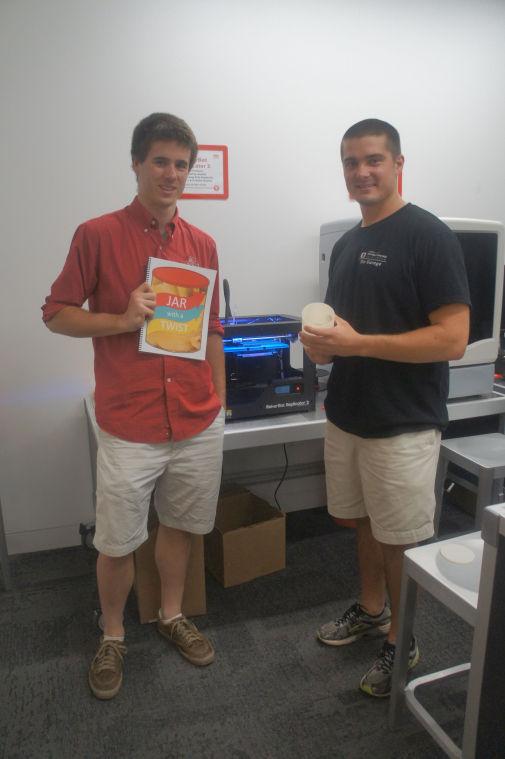 Stephen Smith, left, and Michael Bissette, right, pose with their business model, 3D printer, and model of jar with a twist.