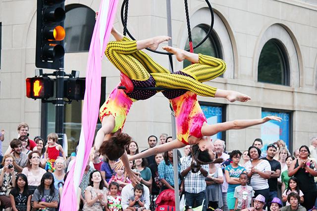 Performers do acrobatics in the air on Fayetteville Street during last year's SPARKcon.