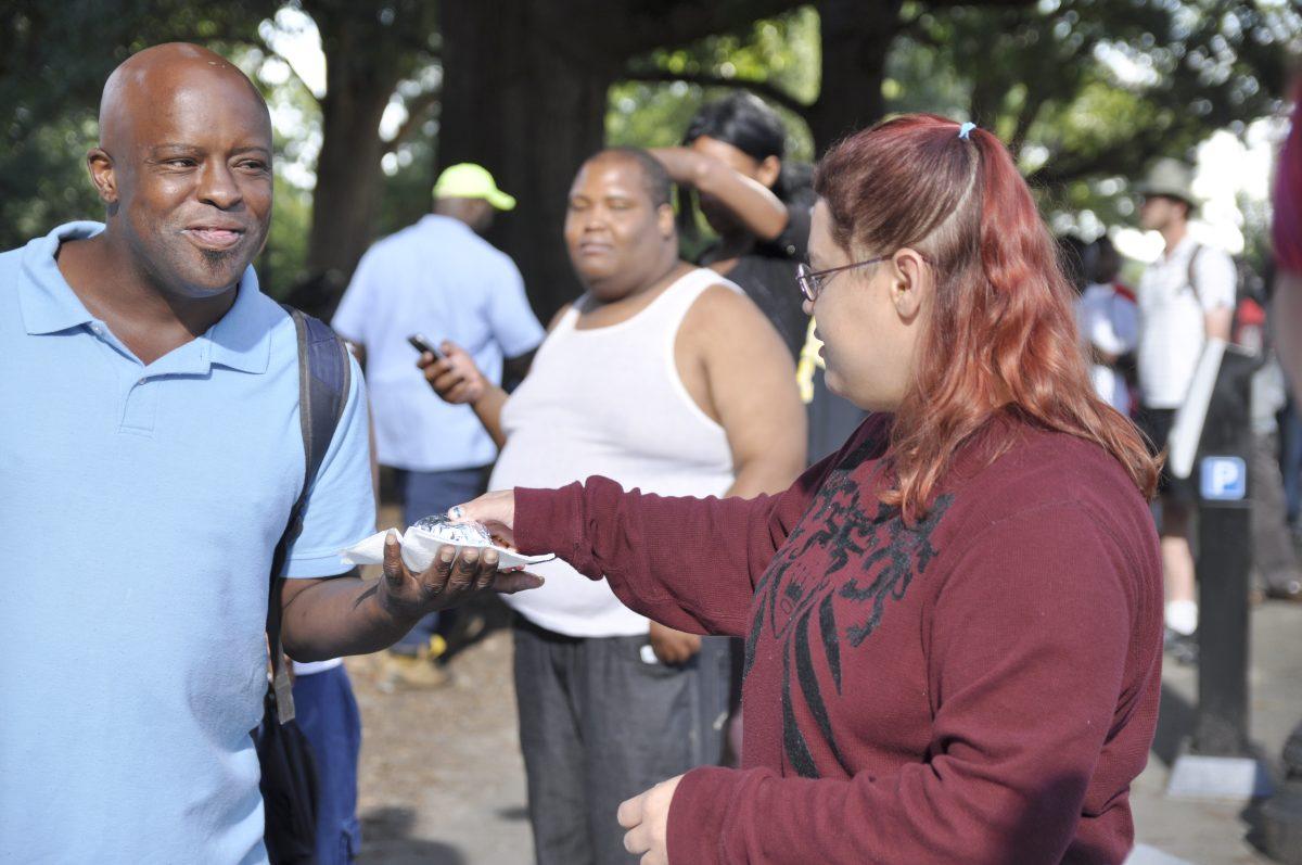Full of care and joy, Cassie Shoemake helps serve the homeless breakfast. Love Wins Ministry provided breakfast to the homeless on Saturday, September 7, 2013 in Moore Square. Photo by Joseph Phillips