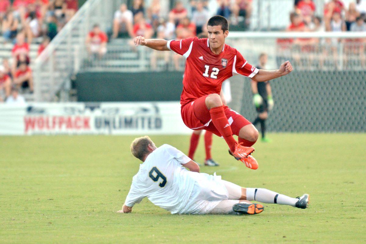 Sophomore midfielder Holden Fender jumps over an opposing player in pursuit of the ball during the conference opening soccer match against new ACC member Pittsburgh at Dail Soccer Field Friday, Sept. 6, 2013. The Wolfpack defeated the Panthers 1-0 in overtime.