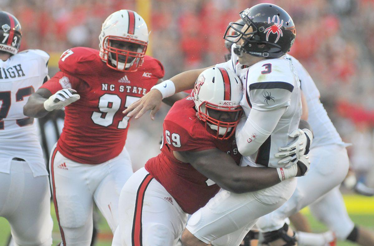 Redshirt junior defensive tackle Thomas Teal tackles Richmond's quarterback just after throwing the ball Saturday, September 7, 2013. Teal had three tackles in the Wolfpack's 23-21 win over the Spiders at Carter-Finley Stadium. Photo by Ryan Parry.