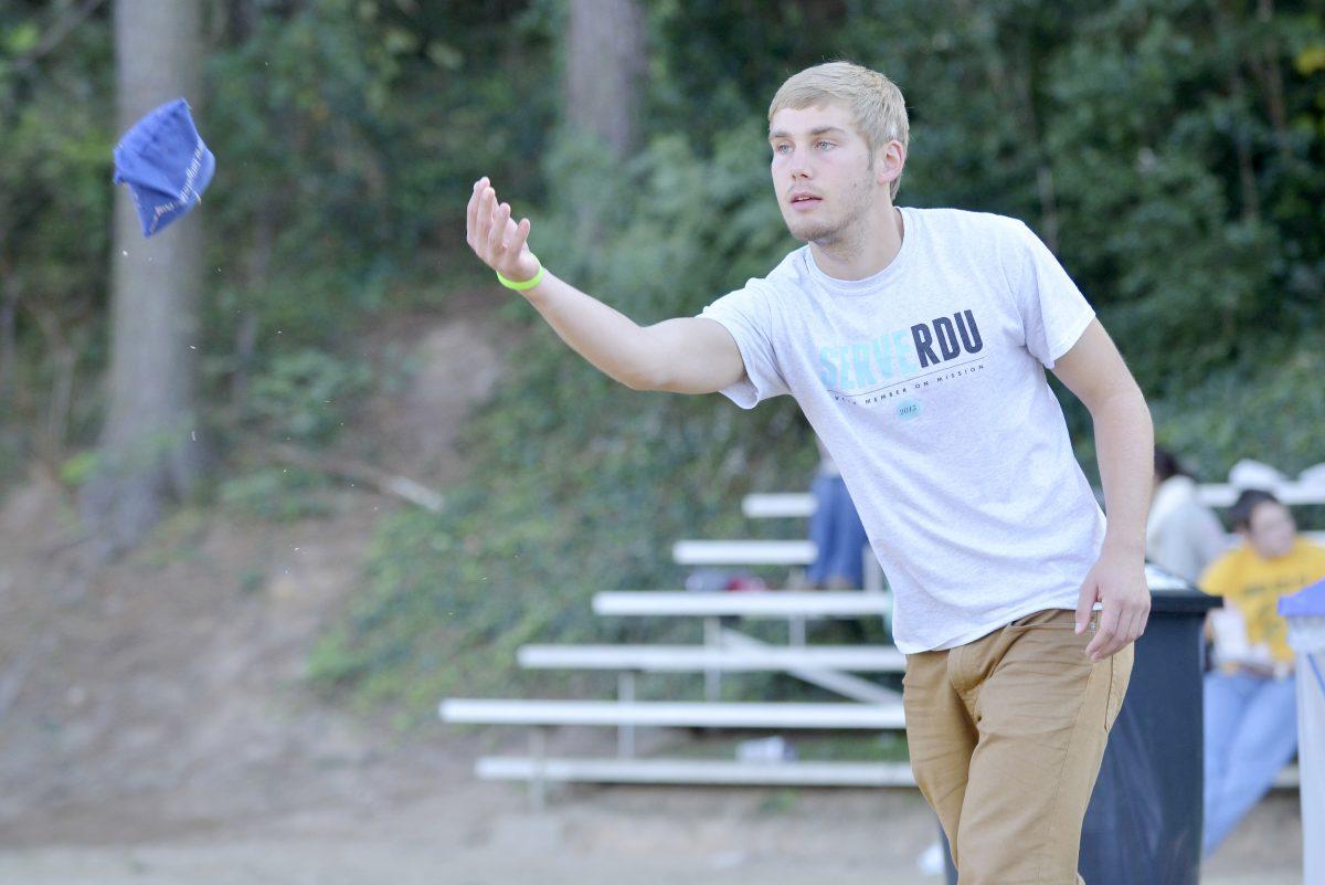 Freshman in First Year College Zach Long throws a beanbag in a game of corn hole at the 2013 homecoming kickoff on the lower Miller field Sunday.