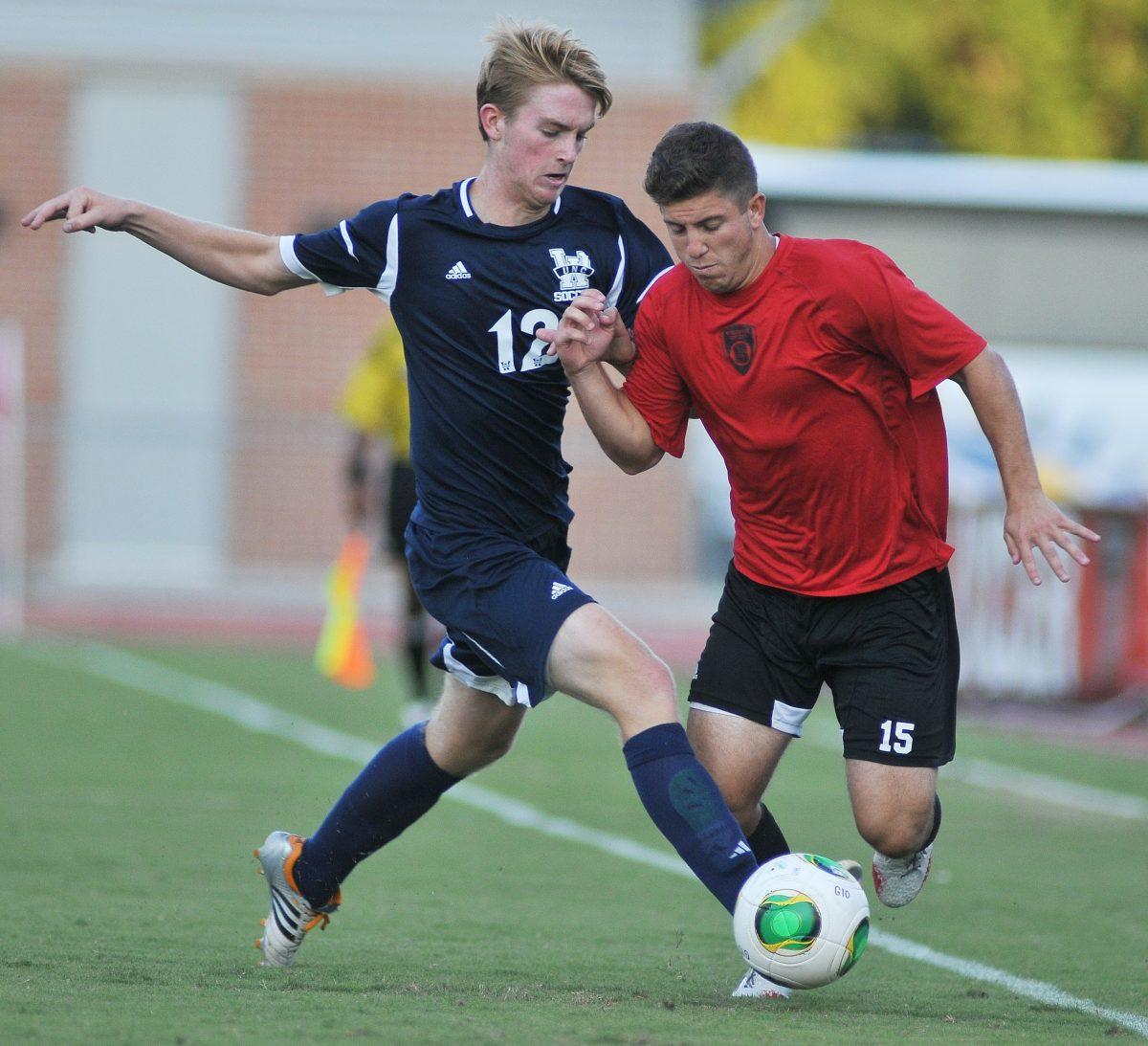 Senior midfielder Alex Martinez gets tackled by a UNC-Wilminton player Saturday, August 24, 2013. The Wolfpack tied the Seahawks 1-1 during their exhibition match at Dail Soccer Stadium. Photo by Ryan Parry.