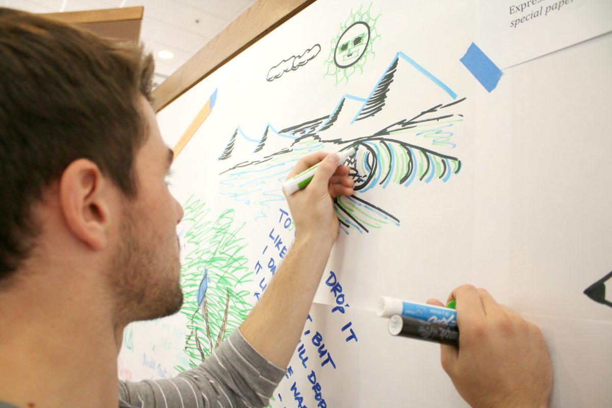 Oliver Walsh, a freshman intending to go into engineering, draws a picture of a surfer on the graffiti wall in Caldwell Lounge Monday. N.C. Sate supported the National Day of Writing by hosting this event.
