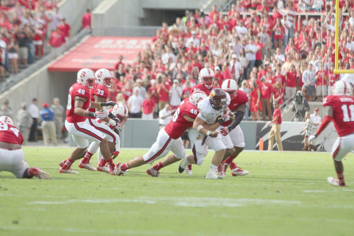 N.C. State freshman linebacker Drew Davis, junior defensive end Art Norman, and junior defensive tackle T. Y. McGill tackle Central Michigan running back Saylor Lavallii during NCSU's 45-14 victory at Carter-Finley Stadium on Saturday, Sept. 28, 2013.