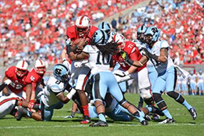 Graduate student quarterback Brandon Mitchell runs the football through a scrum during the homecoming football game against North Carolina in Carter-Finley Stadium Saturday, Nov. 2, 2013. The Tar Heels defeated the Wolfpack 27-19, dropping N.C. State to 0-5 in conference play.