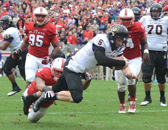 ECU junior quarterback Shane Carden breaks a tackle by freshman lineback Bryan Smith as he dives into the endzone for a touchdown on Saturday. The Wolfpack fell to the Pirates, 42-28.