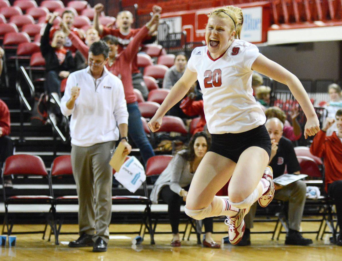 Jumping with joy, freshman defensive specialist Maddie Brown celebrates after NC State wins its second second set against Virginia. The Wolfpack narrowly beat the Cavaliers 3-2 on Friday, Nov. 16 in Reynolds Coliseum.