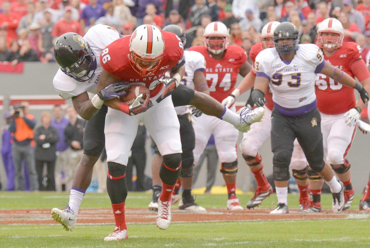 Redshirt freshman tight end David J. Grinnage is tackled during the football game against East Carolina in Carter-Finley Stadium on Saturday. The Pirates defeated the Wolfpack 42-28, dropping N.C. State to 3-8 on the season. Photo by John Joyner.