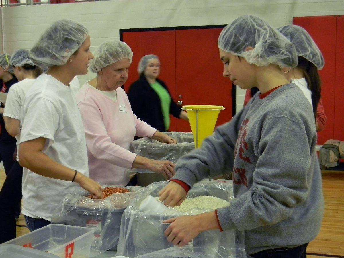 Micaela Hayes, right, a freshman in First Year College, helps scoop cups of rice into bags to be part of packaged meals, which will be sent overseas to victims of hunger Saturday, 9 Nov. 2013.&#160; Hayes said her favorite part of volunteering was knowing that she&#8217;s helping feed kids that are starving.