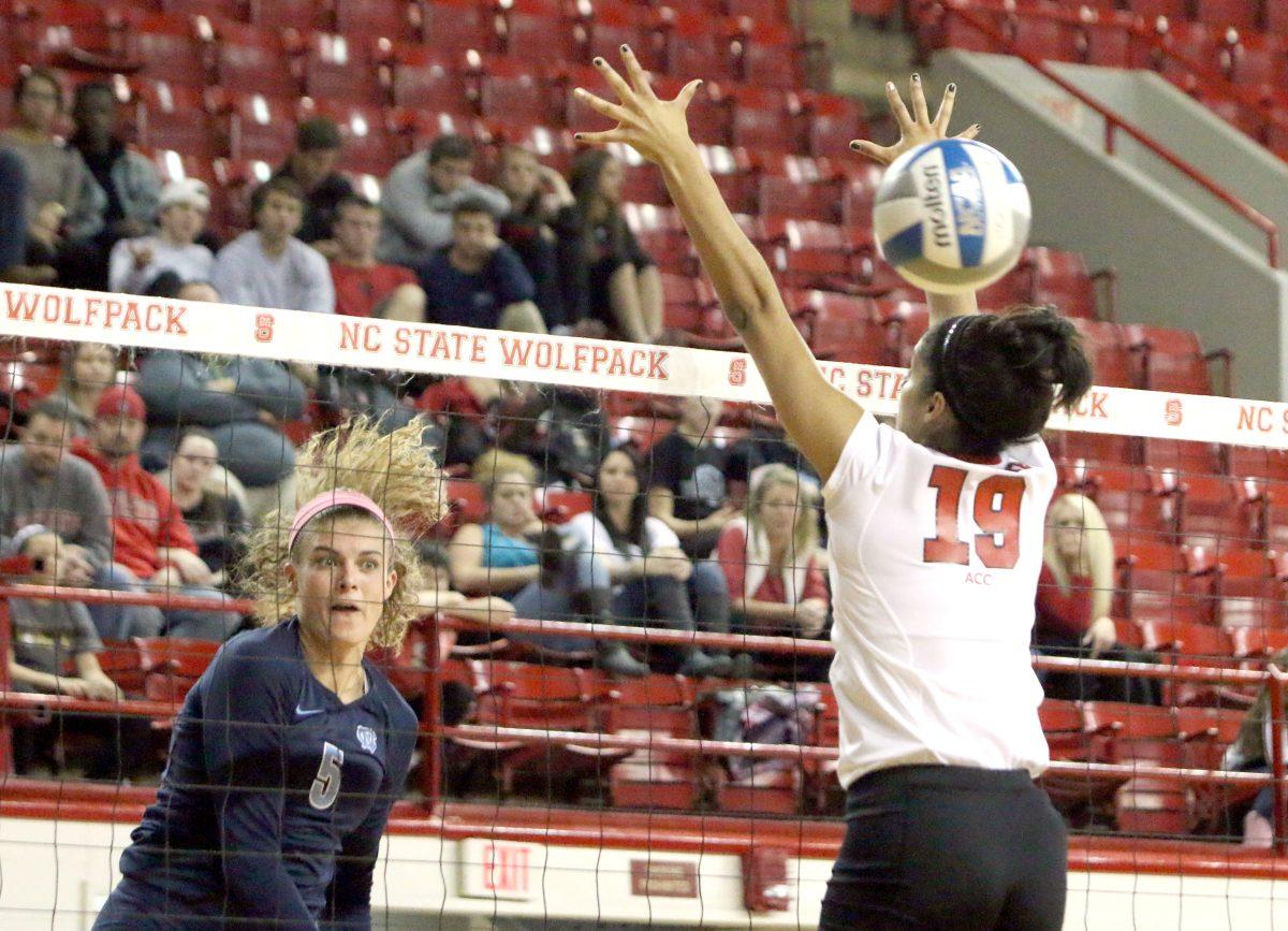 UNC-Chapel Hill sophomore middle blocker Paige Neuenfeldt fires a kill between the hands of junior middle blocker Alesha Wilson. The Wolfpack fell to the Tar Heels in Reynolds Coliseum Wednesday night, 3-0.
