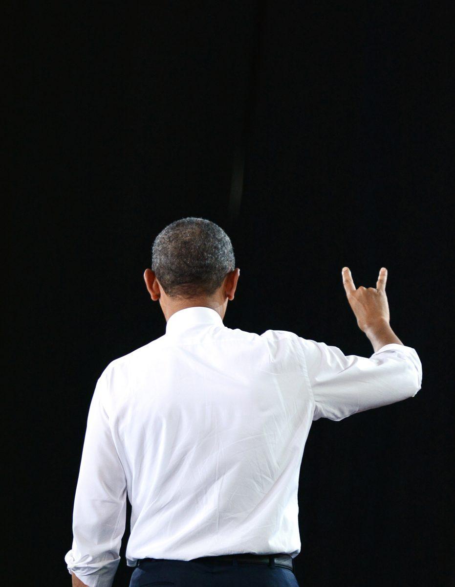 Walking off the stage, President Barak Obama holds up a wolfpack sign in support of NC State. Obama spoke in the J.W. Isenhour Tennis Complex Wednesday, Jan. 15, 2014.Photo by Joseph Phillips