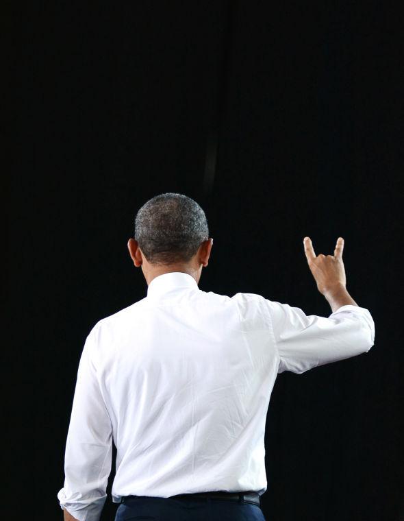 Walking off the stage, President Barak Obama holds up a wolfpack sign in support of NC State. Obama spoke in the J.W. Isenhour Tennis Complex Wednesday, Jan. 15, 2014.Photo by Joseph Phillips