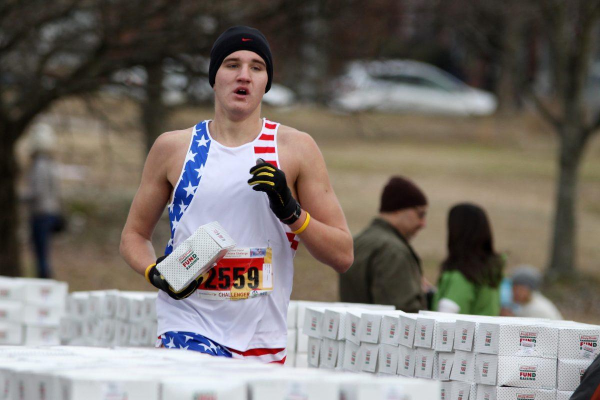 Sixteen year old Jarod Nizen carries his box of doughnuts to Krispy Kreme as he finishes the first leg of the Krispey Kreme Challenge Saturday, February 8 2014 in downtown Raleigh. Nizen finished 20th overall, with a time of 36 minutes and 39 seconds. Photo by Tyler Andrews