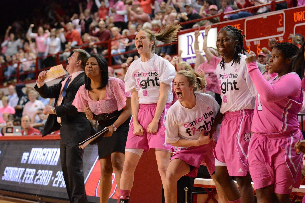 The N.C. State bench, including sophomore guard Kaley Moser, freshman guard Ashley Williams, senior guard Breezy Williams and senior guard Myisha Goodwin-Coleman celebrate a basket during the Hoops 4 Hope game between No. 10 N.C. State and No. 17 North Carolina in Reynolds Coliseum Sunday, Feb. 16, 2013. The Wolfpack fell to the Tar Heels, 89-82. Photo by John Joyner.