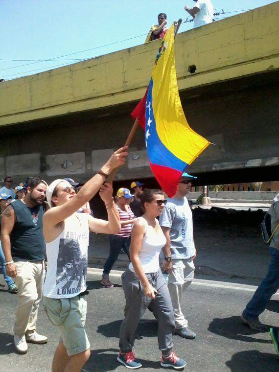 Anti-government protestors raise the Venezuelan flag as they walk through the streets of Caracas, Venezuela. They are wearing white to show their desire for a peaceful return to democracy.