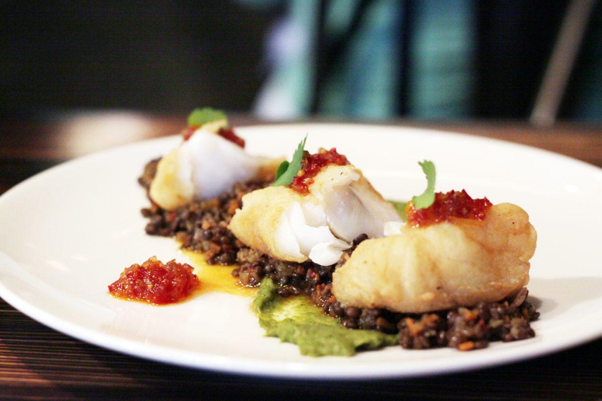 One of Tazza Kitchen&#8217;s dishes is a pan-roasted cod with black lentils, salsa verde, pickled fresno relish and cilantro.