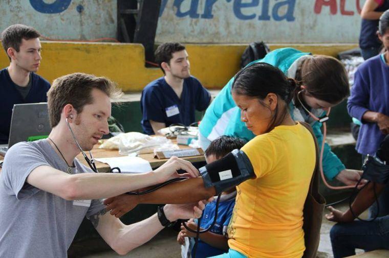 Cary EMS worker Justin Carhart checks a woman's blood pressure in a village outside of Chonta Punta in the Napo province in Ecuador.&#160;