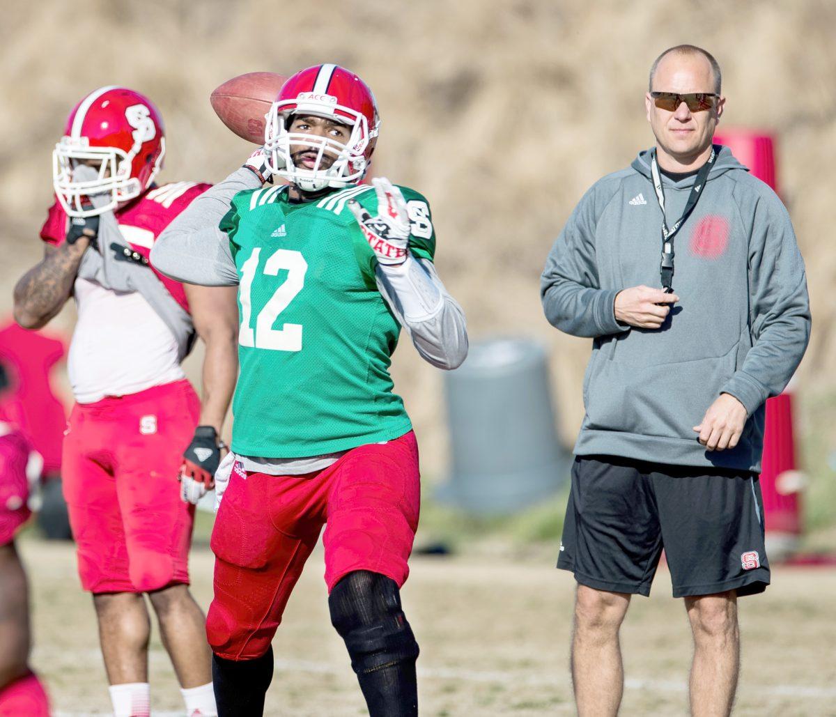 Redshirt junior quarterback Jacoby Brissett throws a pass during practice as offensive coordinator Matt Canada looks on.