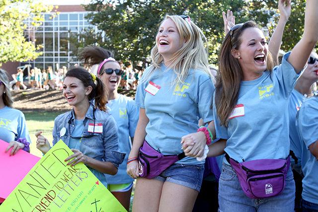 Beth Buckley, a junior in business administration, and Kendele McGee, junior in Elementary Education jump and scream in excitement as they see the new members of their sorority arrive at Bid Day on Harris Field on Sept. 12, 2012. ARCHIVE