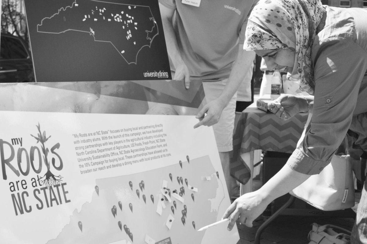 Fatima Boubsis, junior in accounting, pins her personal roots on the map of North Carolina with the help of Tyler Hatch, senior in aerospace engineering.