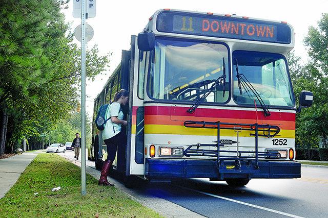 Cameron Millet, sophomore in accounting, boards the No. 11 Avent Ferry CAT bus Tuesday afternoon, Oct. 21, 2014, on Trailwood Dr. Triangle area public buses, including the Capital Area Transit (CAT), Triangle Transit Authority (TTA), and Durham Area Transit Authority (DATA) will all soon be operating under the "Go" brand. Now buses will have similar paint jobs and be operating with similar names like Go Raleigh and Go Durham. All NC State students will still be able to ride for free on the buses with GoPasses, which can be acquired from the university transportation office.