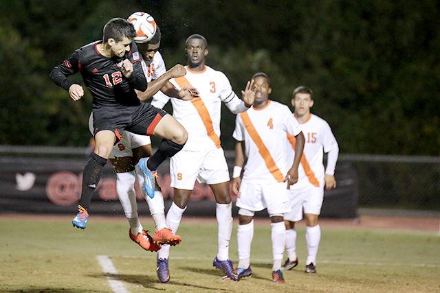 Junior midfielder Holden Fender heads the ball against a horde of Syracuse defenders Oct. 25 at Dail Soccer Stadium. The Wolfpack drew Syracuse nil-nil.