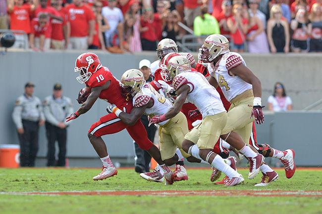 Junior running back Shadrach Thornton runs through a group of defenders during the game against No. 1 Florida State in Carter-Finley Stadium Saturday, Sept. 27. The Wolfpack fell to the Seminoles 56-41.