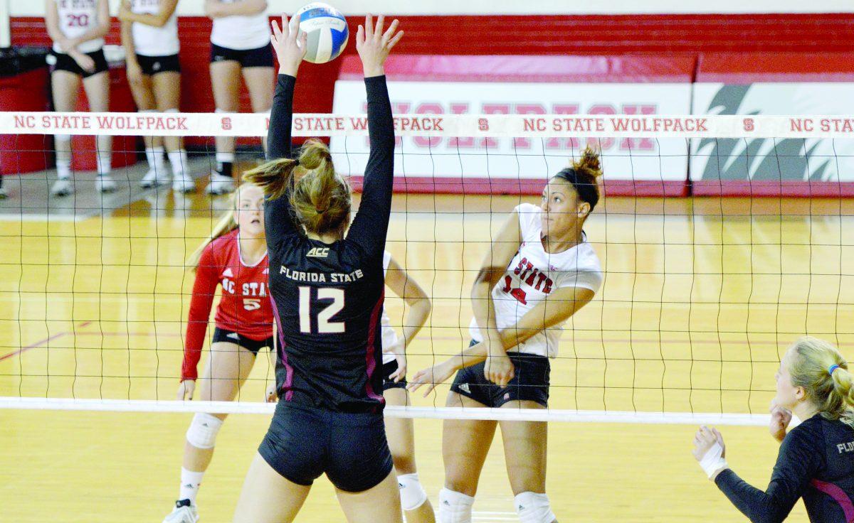 Erica Narel, 14, attempts to block the ball passed over the net by Sarah Burrington of Florida State University. The volleyball game took place on Oct 31, 2014 at Reynolds Coliseum. Although the Wolfpack blocked almost 20 shots, they were defeated, 3-1.